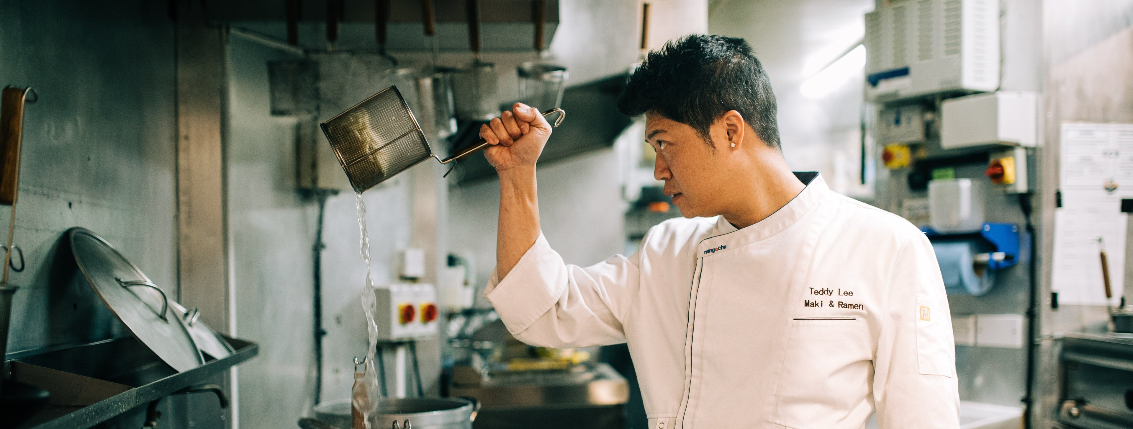 Chef in a professional kitchen holding a ladle